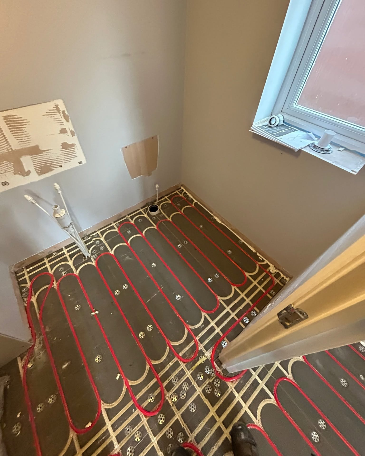 Wet UFH loops installed on a bathroom floor prior to tiling, Greater Manchester