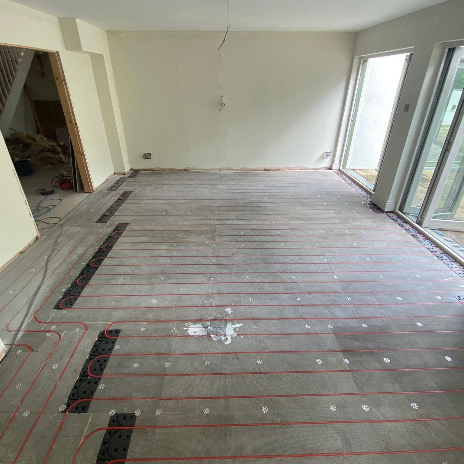 Underfloor heating pipework prepared for screed in an open-plan living area, Rochdale