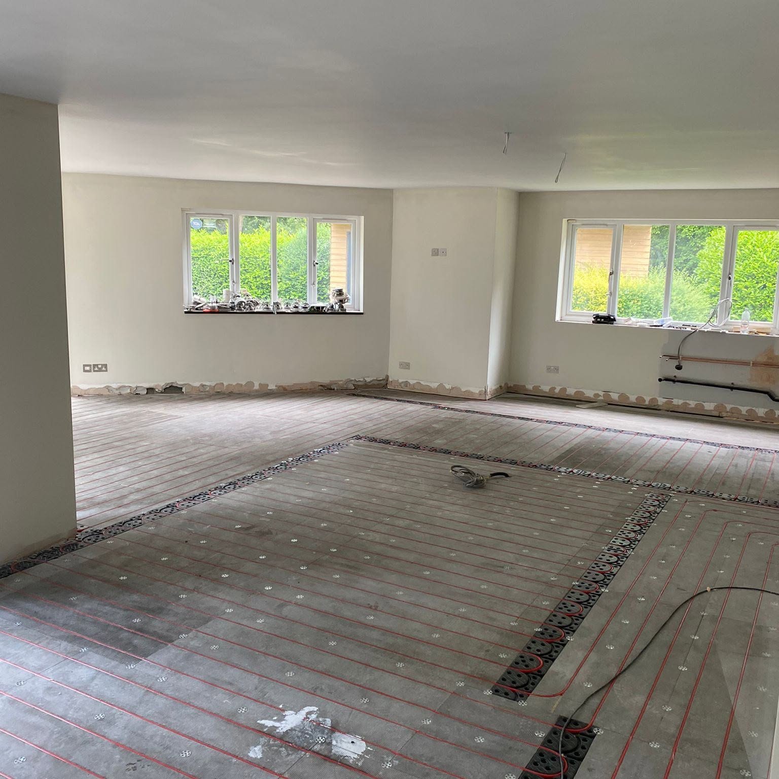 Wet underfloor heating pipe loops laid across a family room by Eco Plumbing & Heating Solutions