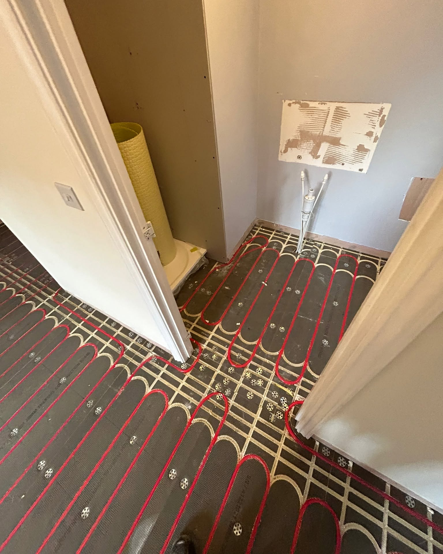 Zoned underfloor heating pipework in a bathroom extension, Oldham